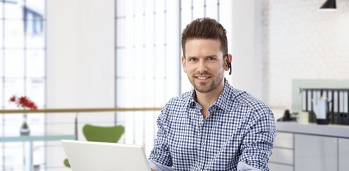 Ein Bueromann mit einem Headset